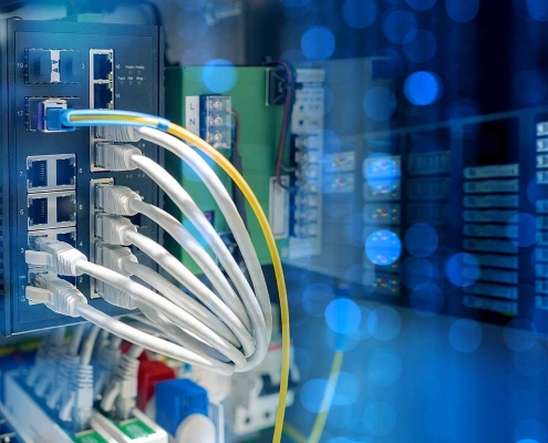 Industrial-grade networking equipment installed in a manufacturing facility with structured cabling and rugged wireless access points.